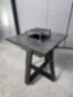 Brasero plancha en acier noir mat avec piètement en croix robuste, conçu par Esprit Métal.