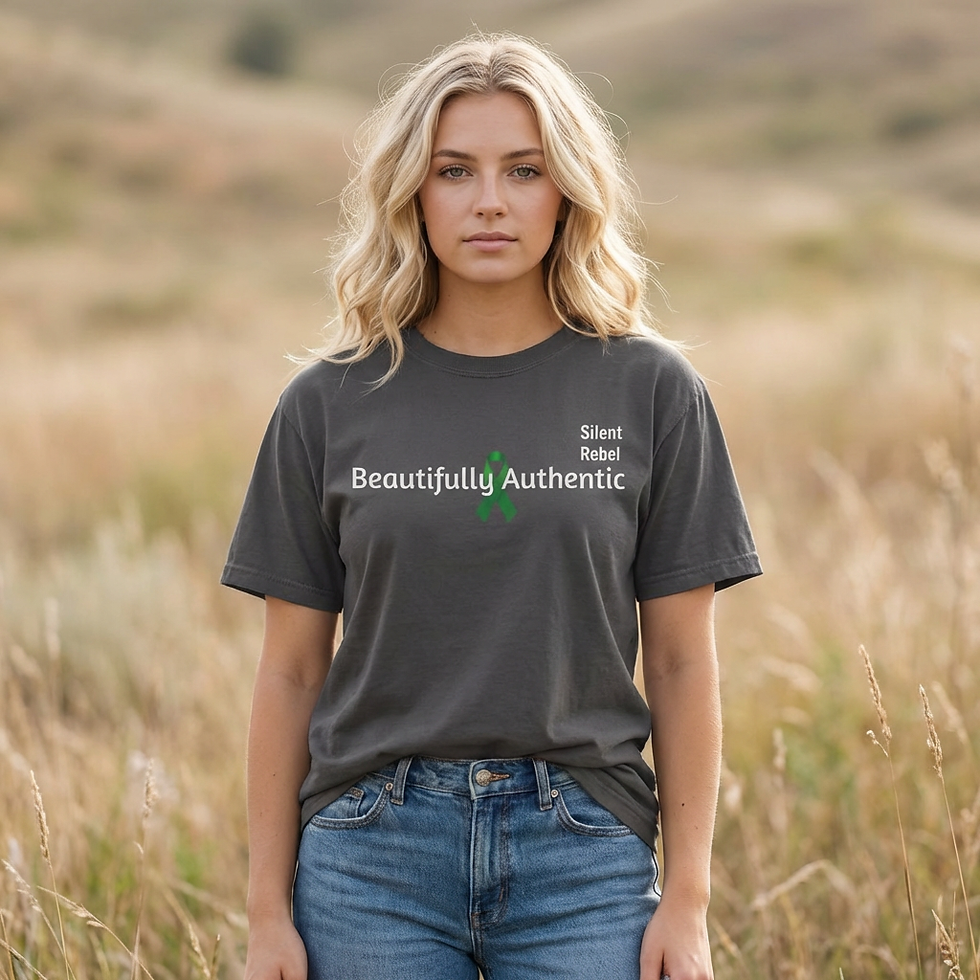 A person stands outdoors in a natural setting wearing a dark Tāshirt with white text across the back. A green awareness ribbo