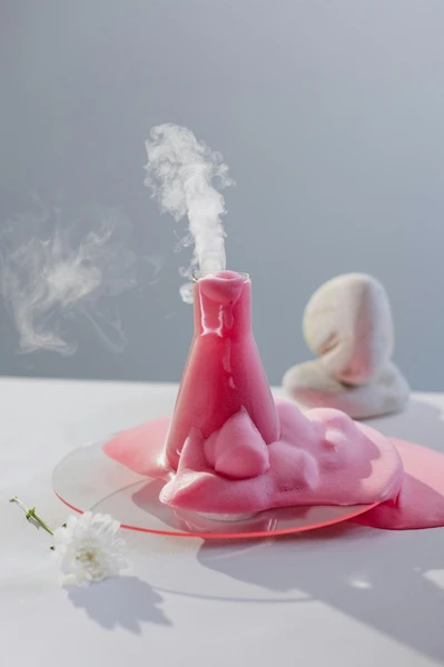 a pink liquid in a beaker with smoke coming out of it