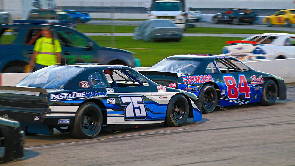 Delaney Gray (84) leads Dustin Phillips (75) through turns one and two during an overtime finish in the Davey Allison Memorial at Carteret County Speedway. (Andy Marquis photo)