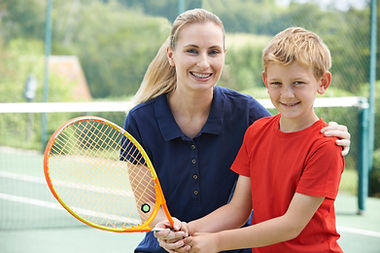 Junge mit Tennis-Trainer
