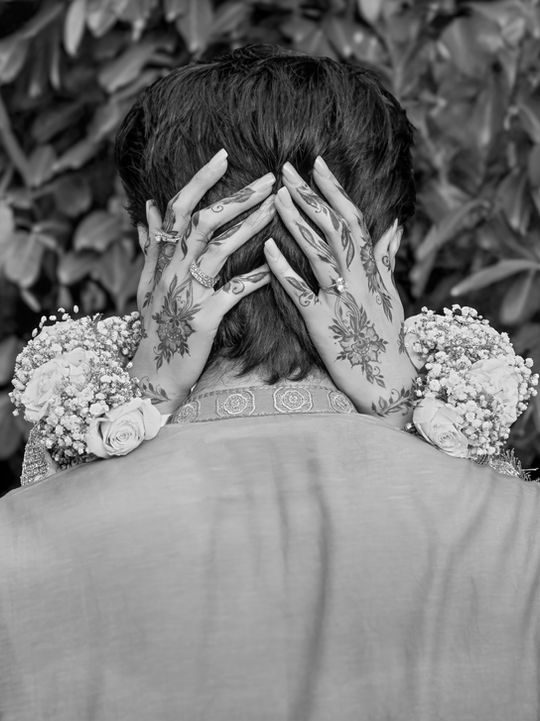 Bride’s hands adorned with intricate henna designs, captured in close-up detail during a wedding celebration. Taken by Win.Co Photography at Asian wedding in Buckinghamshire and Slough. 