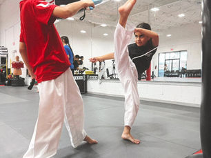 Team One Taekwondo student practicing a high kick against a target pad in McAllen, TX