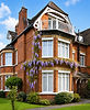 Red brick Windsor building with purple wisteria and balcony