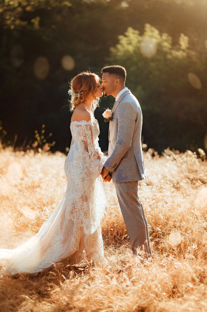 bride and groom kissing holding hands in a meadow off a hiking trail