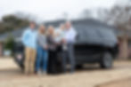 The Cannon family standing together in front a of an SUV.