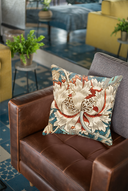 A William Morris cushion featuring a close up of his Honeysuckle and Tulip design rests on a chair