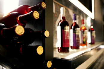 A display showcasing Saint Sadler Wines, featuring an elegant arrangement of various wine bottles from their collection, highlighting the brand's sophistication and heritage.