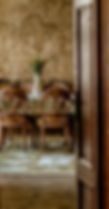 Elegant vintage dining room with carved wooden chairs and floral tapestry