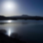 sun reflecting in water with mountain in the background.jpg