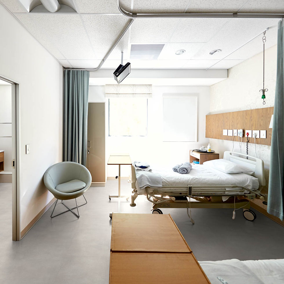 Ziekenhuis kamer met bed, stoel en gordijnen.