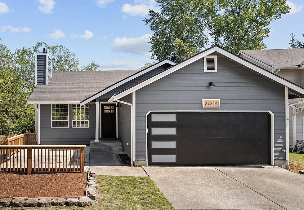 Gray suburban house with black garage door, front porch, and driveway; house number 27214 under a blue sky.