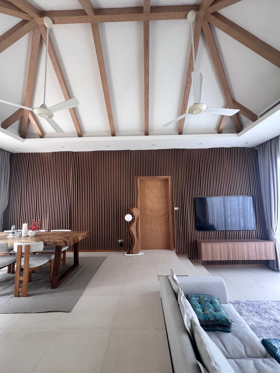 Spacious room with wooden beams and modern furniture.