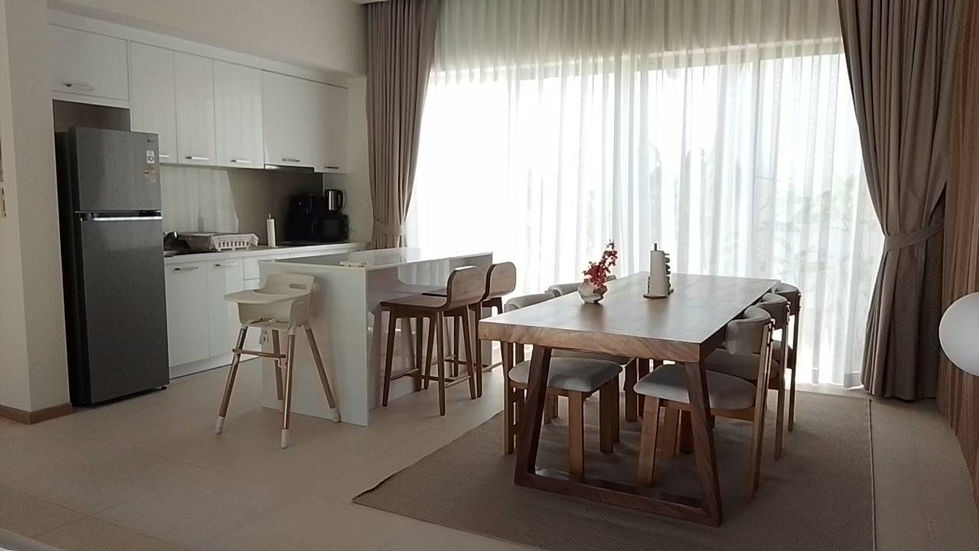 Modern dining area with table, chairs, and kitchen.
