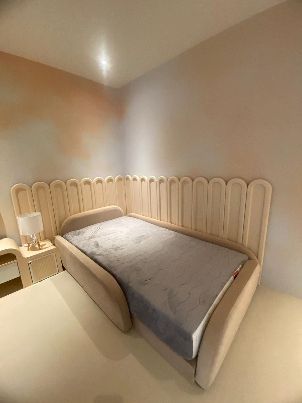 Cozy bedroom with single bed and nightstand lamp.