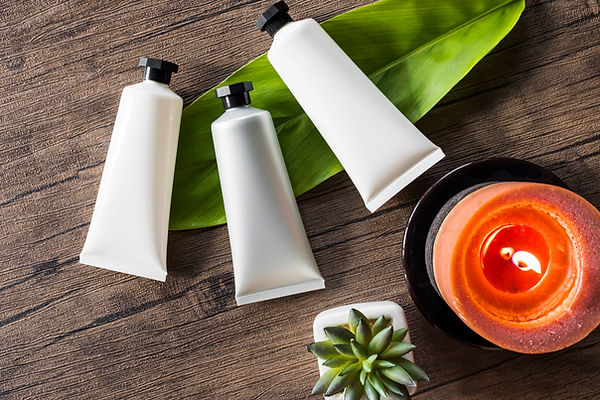 three_spa_cosmetic_products_with_lighted_candle_wooden_background.jpg