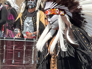 native dancer, colorful costume, drummer in background