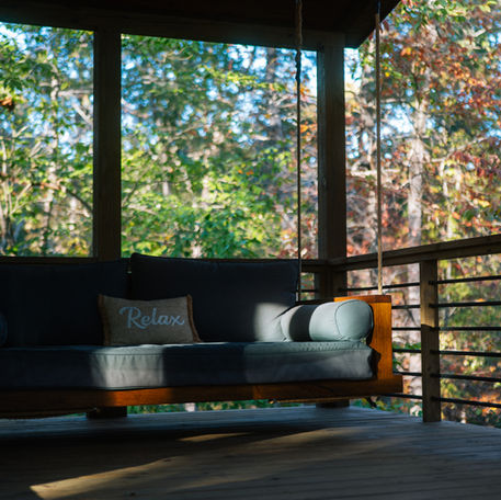 The large bed swing on the side deck of Haven's Treehouse