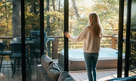 Guest opening the double sliding glass doors in the living room of Haven's Treehouse to step onto the back deck