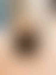 A towel and blanket folded into the shape of an elephant sitting down with 3 wrapped pieces of chocolate.