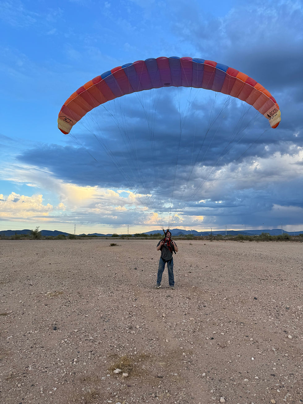 Wide angle view of a group paramotoring above a scenic landscape
