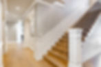 Grand foyer with white doors and elegant staircase and wraught iron.jpg