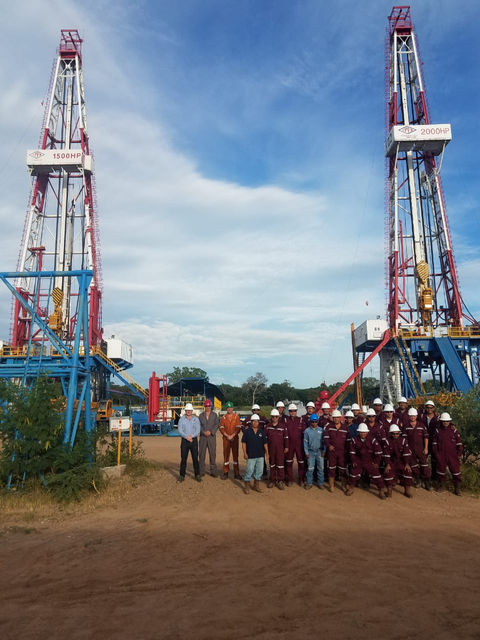 team of workers stood between 2 large pillars 