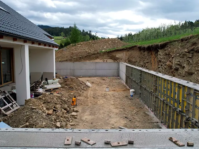 Dronový pohľad na výstavbu oporného múru pri rodinnom dome na svahovitom pozemku