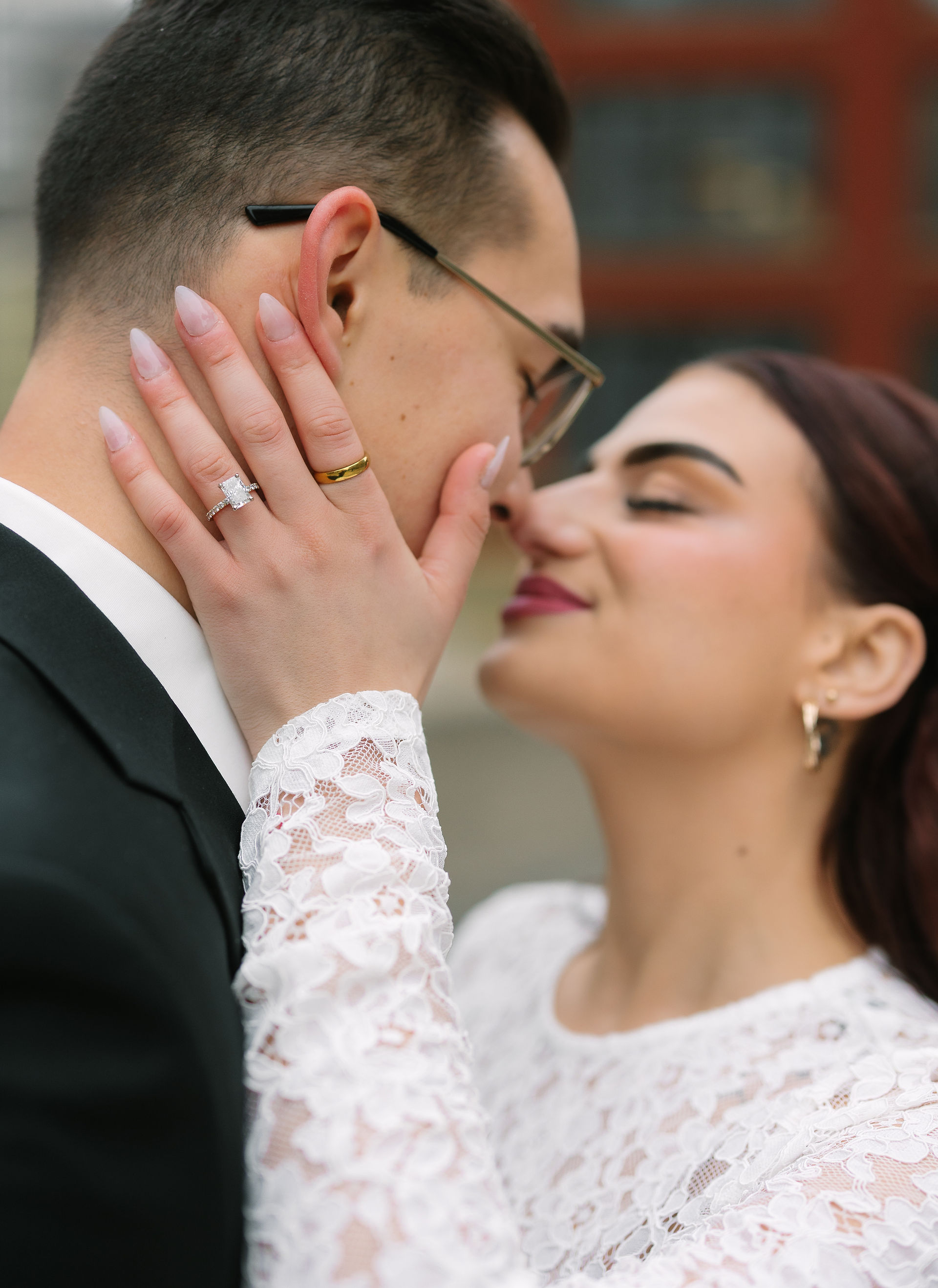 A&A lean into each other in front of a Detroit landmark, their elegant attire and sultry expressions capturing both passion and place.