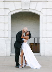 A romantic shot of S&J standing in front of the grand entrance of the Detroit Institute of Arts, embracing amidst the stunning architectural backdrop.