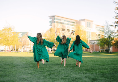 MSU graduates celebrating together near the Spartan Statue in East Lansing