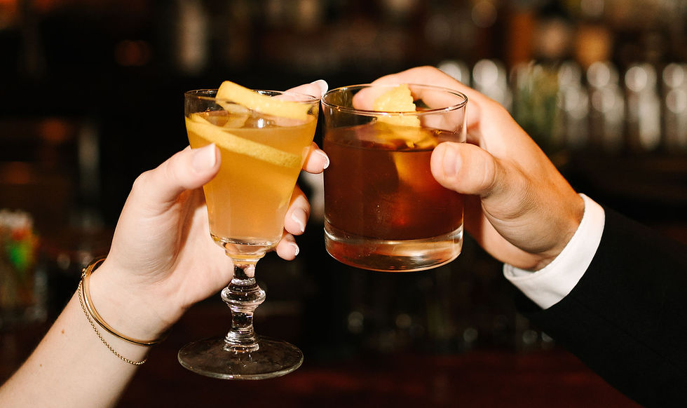 Couple enjoying cocktails during engagement photos at Sugar House Detroit bar