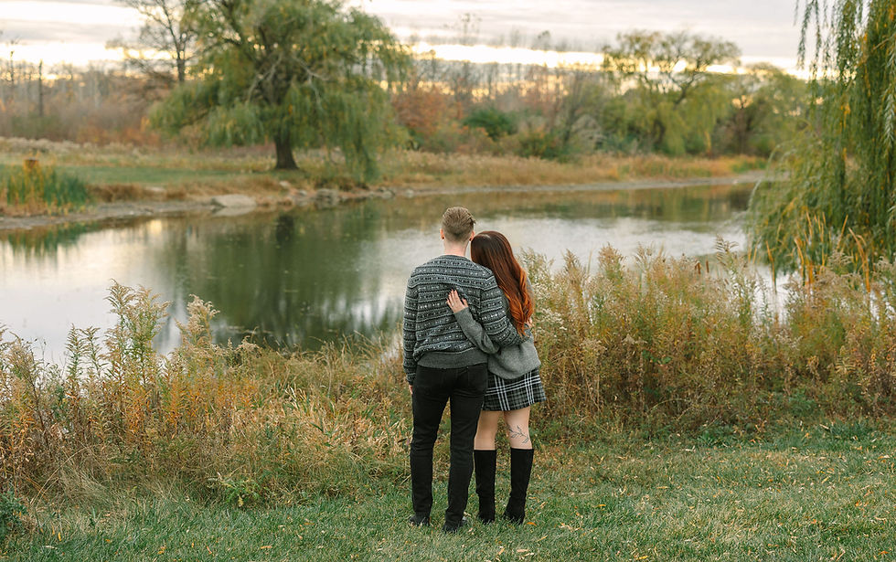 Candid engagement photo of couple along the river on Belle Isle in Detroit