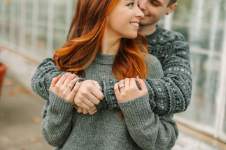 Candid engagement photo of couple walking along the river on Belle Isle in Detroit