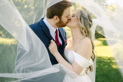 Wedding photographer capturing bride and groom portraits at Creekside Acres Event Barn in Goodrich, Michigan.