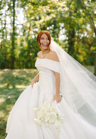 Bride and groom exchanging vows at a Michigan backyard wedding under trees with white drapery and lush greenery