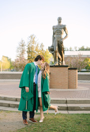 MSU graduates celebrating together near the Spartan Statue in East Lansing
