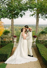 Wedding couple posing in Pine Knob Mansion gardens surrounded by early fall colors