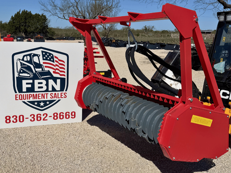 mulcher skid steer attachment sitting outside next to a FBN Equipment sales sign