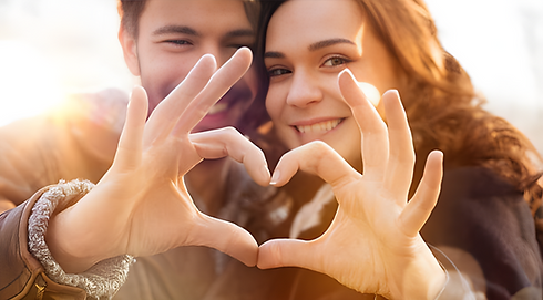 happy couple making a love heart with their fingers