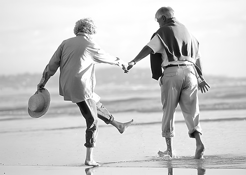 older couple holding hands on beach
