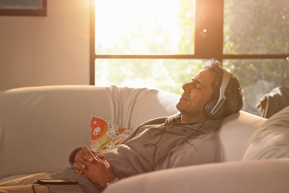 Man Relaxing And Listening To Music Through Headphones