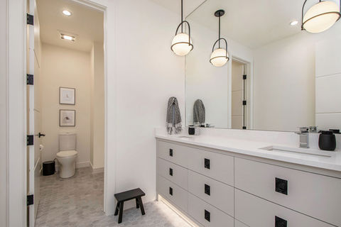 Modern bathroom with vanity, mirror, and toilet alcove