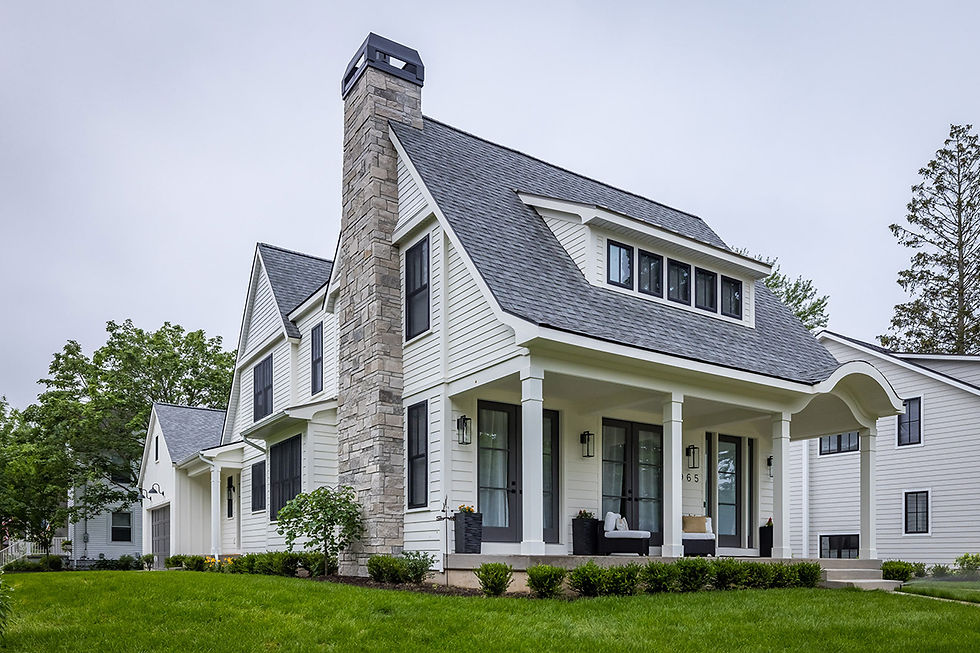 Custom built home with white siding and stone chimney