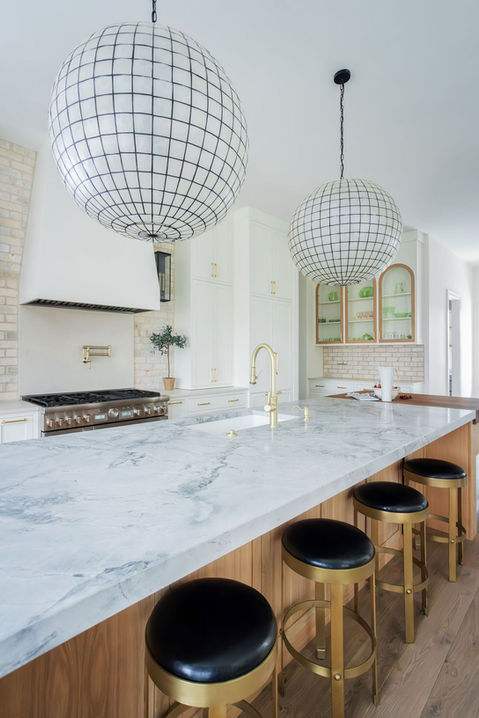 Kitchen island with marble counter, bar stools, sphere lights