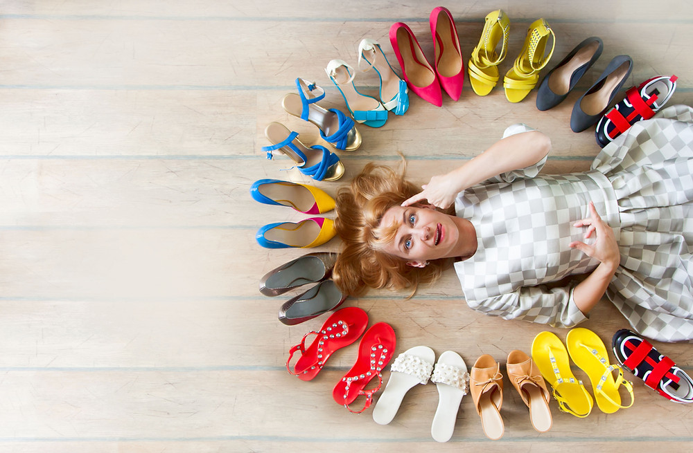 person laying on the ground with shoes all around
