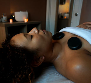 Woman laying with hot stones on her.