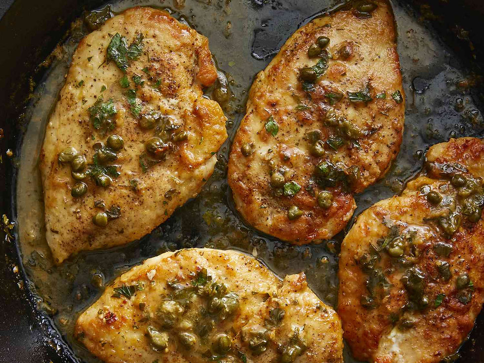 Chicken piccata with capers and parsley in a pan, sizzling in a golden-brown sauce. The setting is rustic and appetizing.