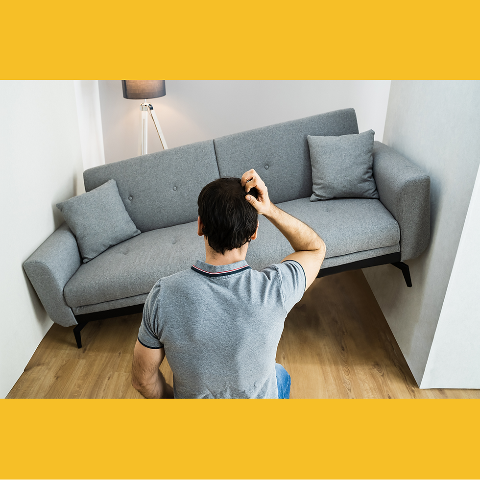 Man sitting on floor facing a gray couch symbolizing leadership uncertainty in AI-driven workplace transition.
