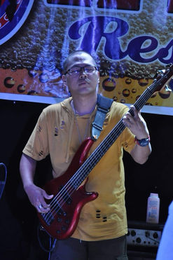 Gruelle, bassist of The AC Project, Toronto’s first all Filipino-Canadian wedding and event band playing red bass guitar on stage.